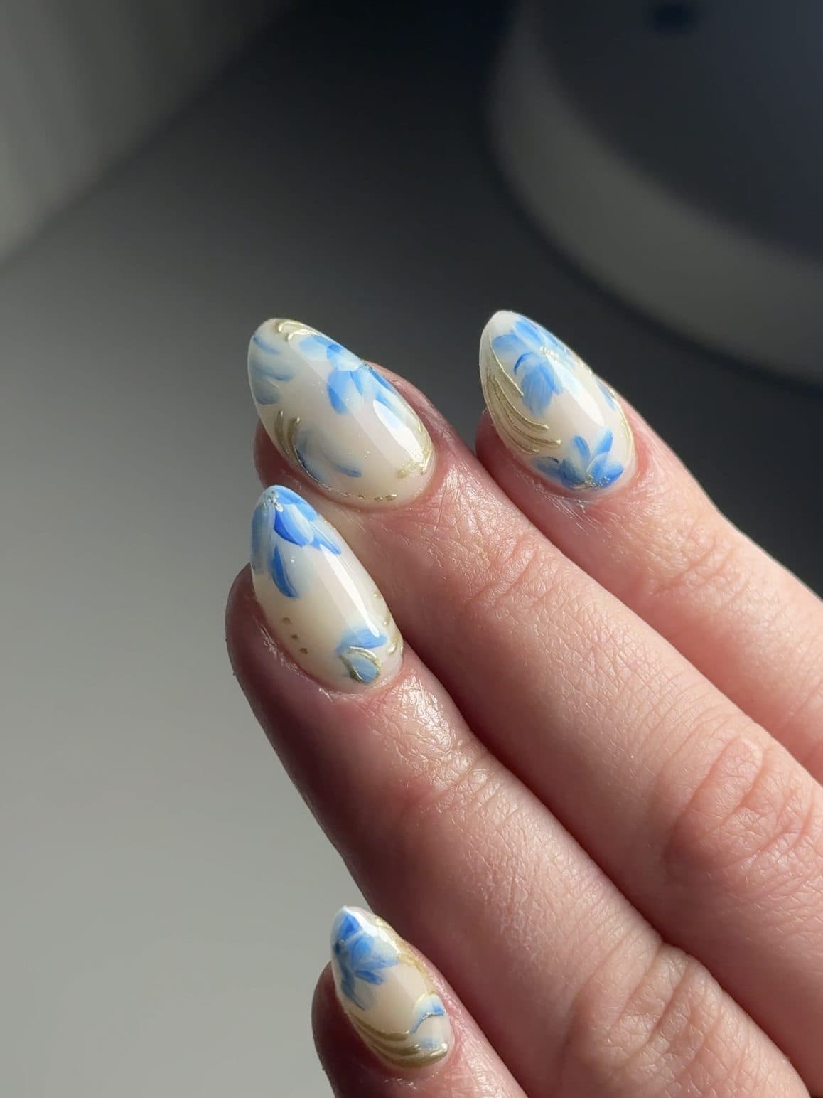 Milky almond Gel-X nails with hand-painted blue watercolour florals