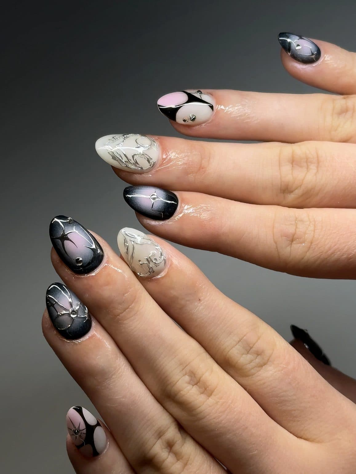 Almond Gel-X nails with smoky black ombre, painted white butterflies and silver detail