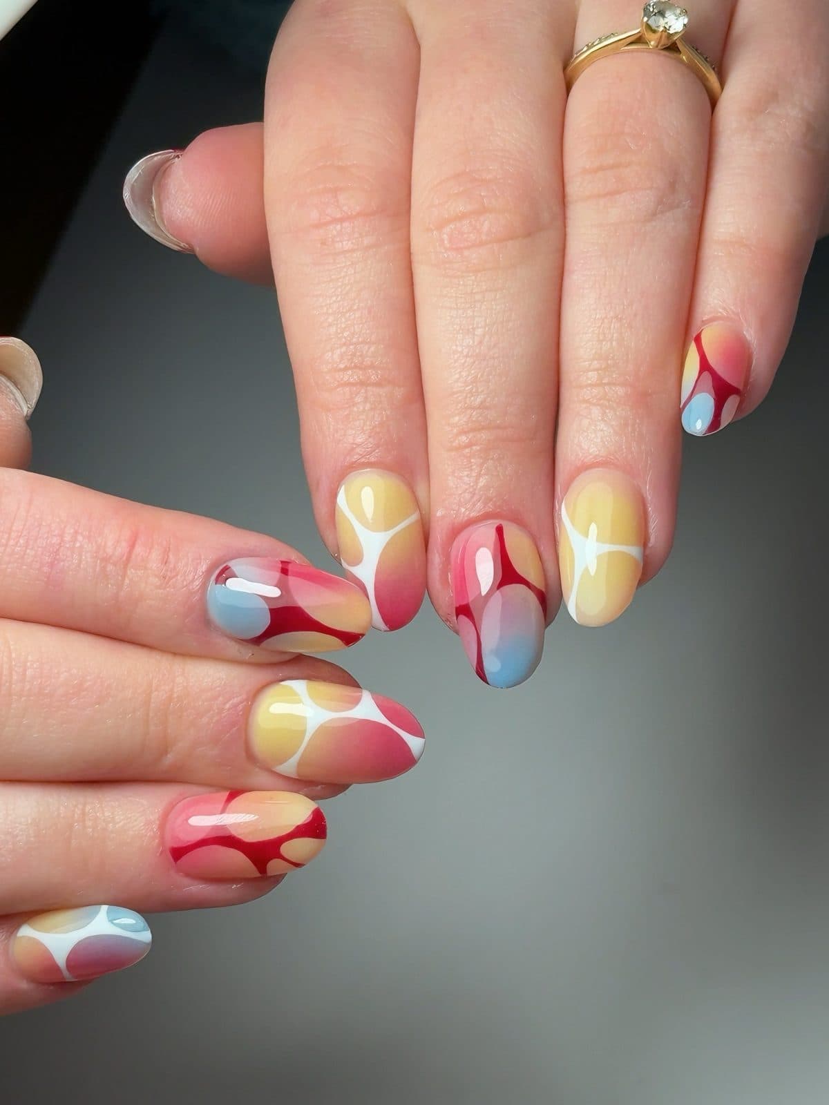 Bright almond Gel-X set with red, yellow and blue abstract swirls and outlined shapes