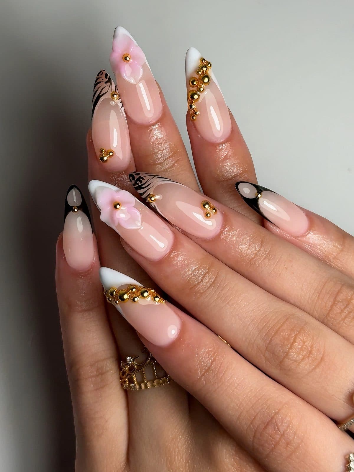Almond Gel-X set with white French tips, pink 3D flowers and gold charms at Vynl Studio