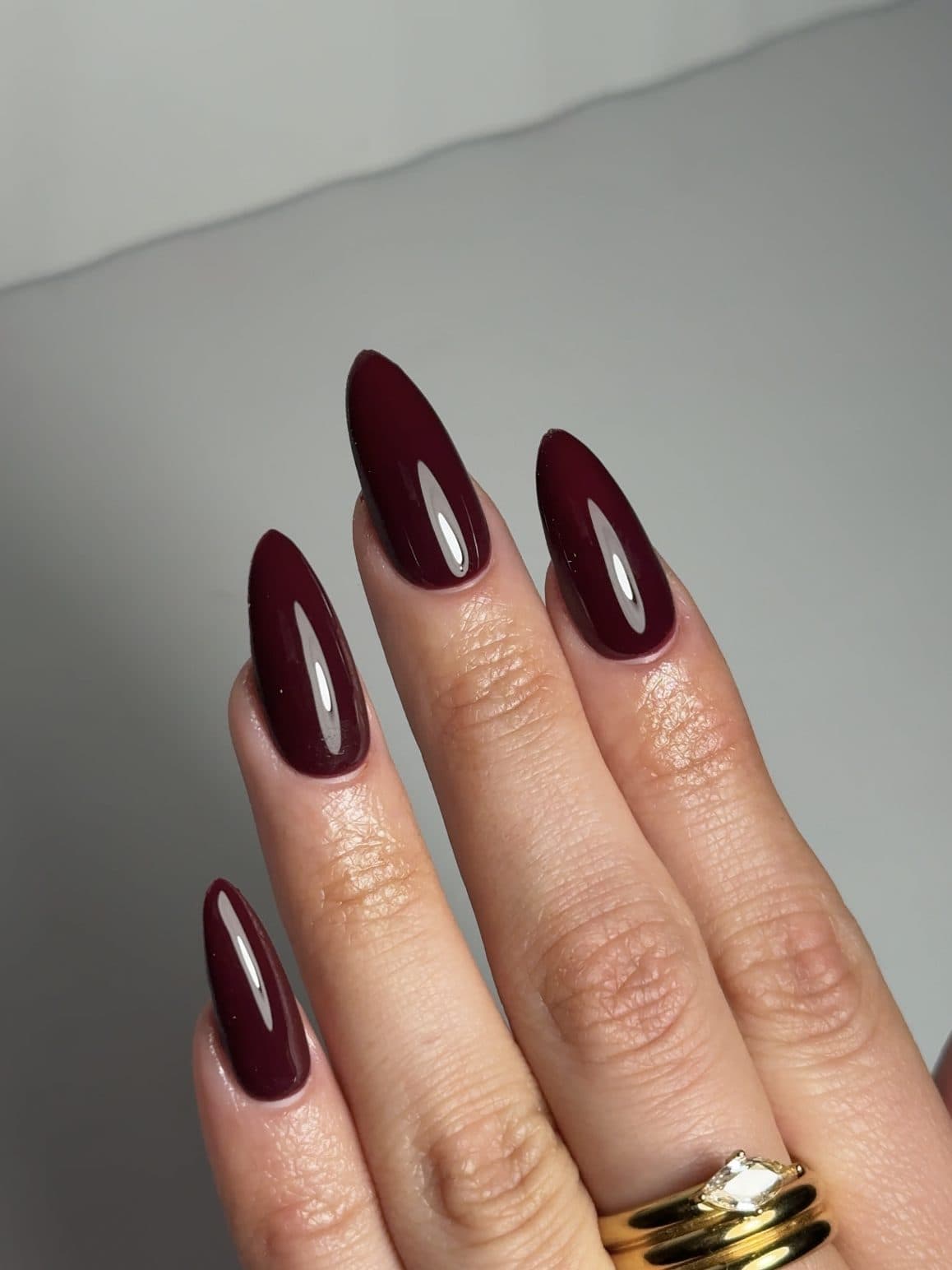 Glossy deep plum almond Gel-X nails